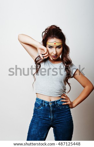 Studio portrait of girl with asian appearance and bright make up with red star on forehead