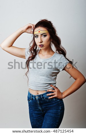 Studio portrait of girl with asian appearance and bright make up with red star on forehead