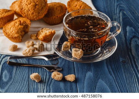 Traditional breakfast with black tea and croissants, vintage wooden background, selective focus