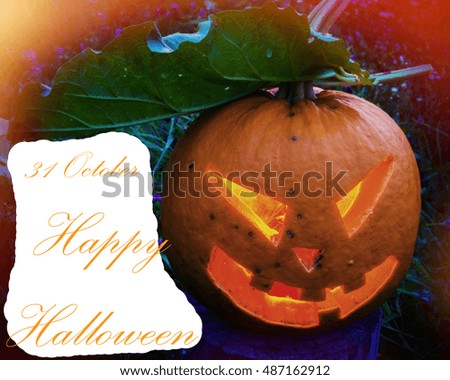 Scary pumpkin covered with foliage on Halloween on a background of grass and the text