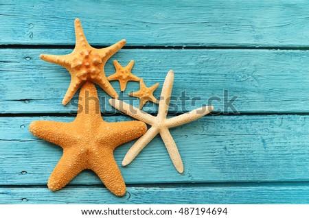  Starfish on blue wooden background. Top view with copy space. Summer concept.