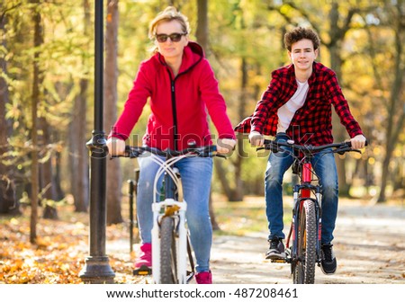 Healthy lifestyle - people riding bicycles in city park ( focus on boy )