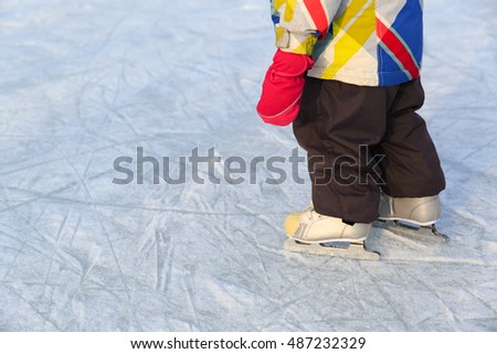 child learning to skate on ice in winter snow