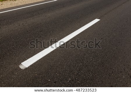  photographed close-up of road marking is located on the roadway, white line on the pavement