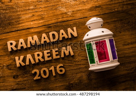 Image of word RAMADAN kareem 2016 and colorful lantern on wooden background, close up. empty copy space for inscription or other objects. Religion and holiday backdrop