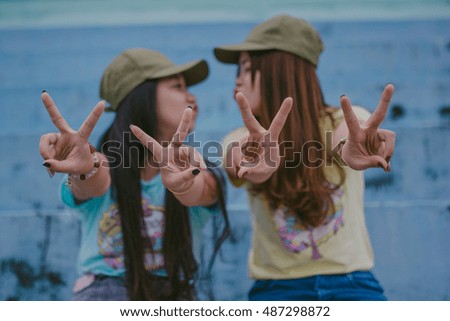 Best friends. Two girls friends laughing and kissing at stadium