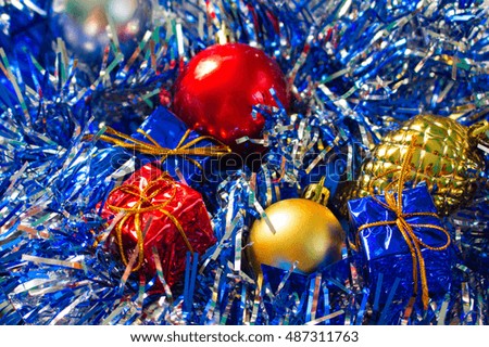 Christmas ornament background. Red and gold ball. Golden pine. Blue and red wrapped gifts. Sparkling ribbon with needles. Close-up photo for New Year greeting card, seasonal holiday banner template