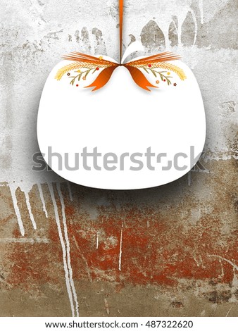 Close-up of one blank pumpkin shaped frame hanged by brown ribbon on dirty concrete wall background