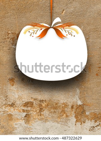 Close-up of one blank pumpkin shaped frame hanged by brown ribbon on rough weathered brown concrete wall background