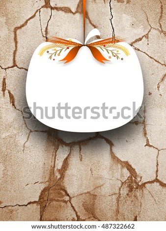 Close-up of one blank pumpkin shaped frame hanged by brown ribbon on cracked wall background