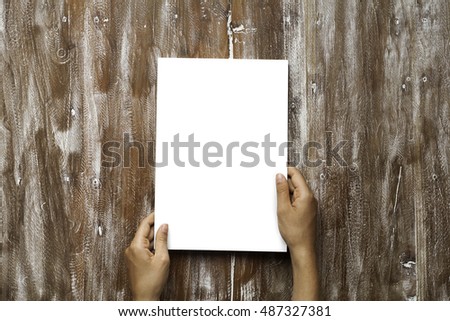 Closeup Blank White Paper Sheet Mockup Holding Male Hands Natural Wood Table Background. Empty Canvas Painted Brown Desk