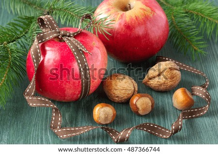 Christmas food background. Apples with nuts on wooden table. Vintage style.