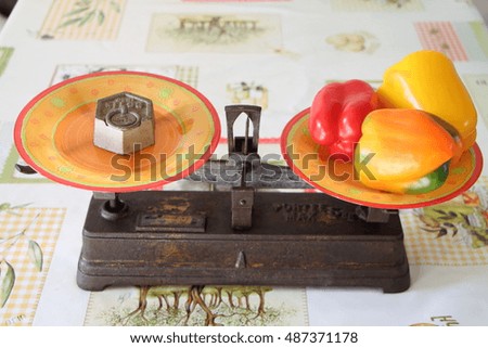 old two pans balance scale with peppers