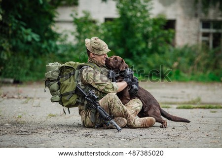 Military Man Hugs Dog Royalty-Free Stock Photo #487385020