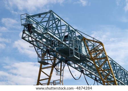 The elevating crane on a background of the light-blue sky