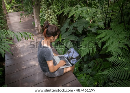 woman holding tablet PC in garden