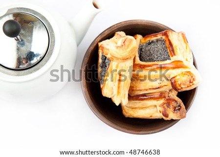 Freshly baked flaky croissant with poppy in ceramic on a white background