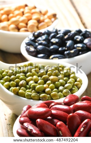 lentils in spoon on wooden background. mung bean, soybean, red bean , black bean 