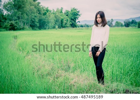 Lifestyle portrait of pretty young hipster woman making photo in the field.
