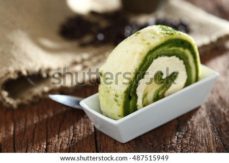 Matcha green tea cake roll for coffee break, coffee time (Low key picture and selective focus)