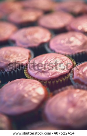 Pastel pink cupcakes fresh from oven with frosting