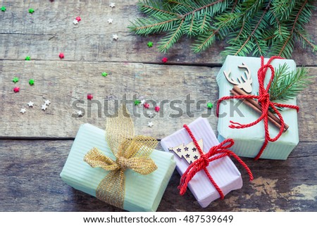 Christmas background with decorations and gift boxes on wooden board/toned photo
