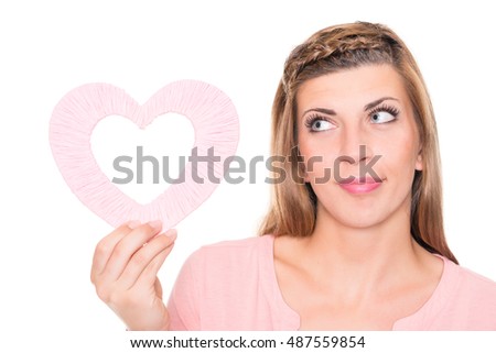 Smiling young woman with pink heart in front of white background