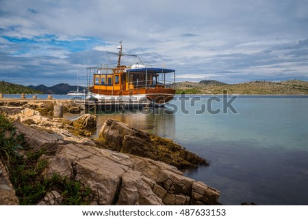 Isolated boat stopped and anchored in the calm waters and colorful, Kornati islands, Dalmatia, Croatia, Europe / boat / boats / Islands / Green water / Mediterranean sea