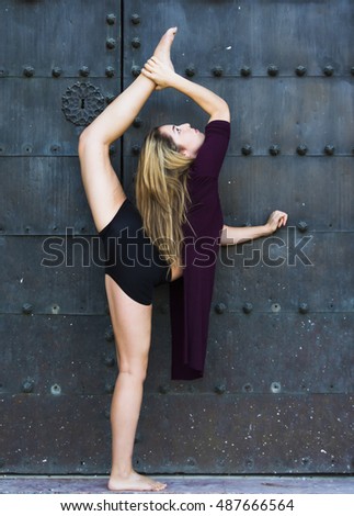 Beautiful ballerina doing exercises for dancing outdoors in a park
