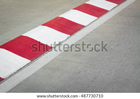 Motor racing circuit Red and White. White and red strip no Parking Sign on Footpath road. Road sign. Red and White sign on road. Motor race asphalt.  white and red of concrete road texture background.