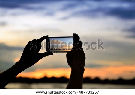 People use mobile phones to take pictures.sunset view