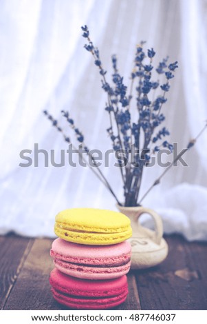 French macaroons and lavender on wooden table. Vintage toned food still life.
