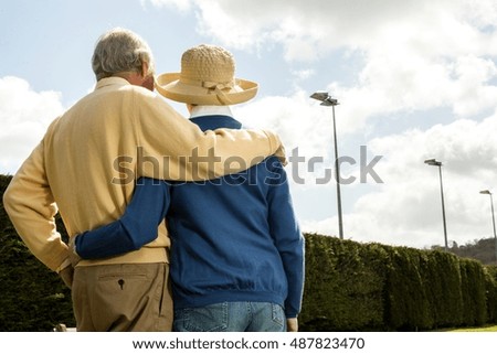 Back view of husband and wife looking at hedge