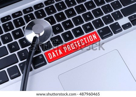 Close Up of Stethoscope and DATA PROTECTION written on laptop keyboard.