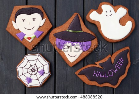 Dracula, witch, ghost, bat, spider in web. Halloween homemade gingerbread cookies on wooden background. Top view.