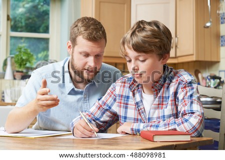 Male Home Tutor Helping Boy With Studies Royalty-Free Stock Photo #488098981