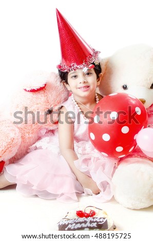 Cute little baby girl Celebrating her birthday surrounded with cake, Teddy bear doll,red balloons & hat isolated in white background