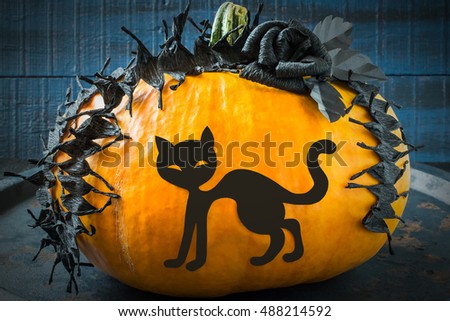 Idea homemade decorating for Halloween. Application: barbed tape made of black crepe paper and cat on pumpkin. The original design in the style of Halloween. Tinted photo
