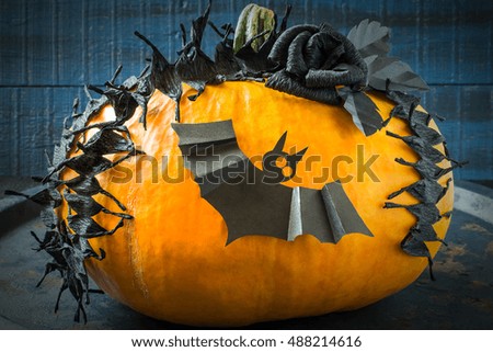 Idea homemade decorating for Halloween. Application: barbed tape made of black crepe paper and bat on pumpkin. The original design in the style of Halloween. Tinted photo