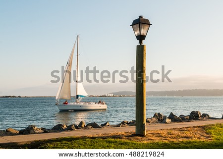 Lamp on Harbor Island with sail boat in San Diego Bay.