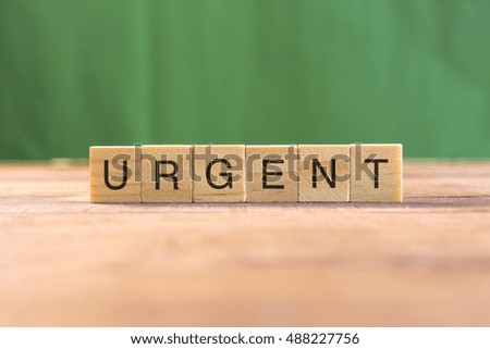 the word of URGENT on wood tiles concept