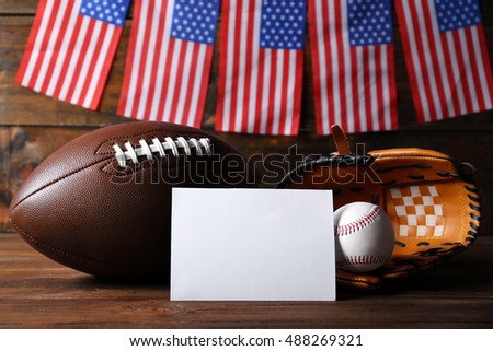 American flags with sport items on wooden background