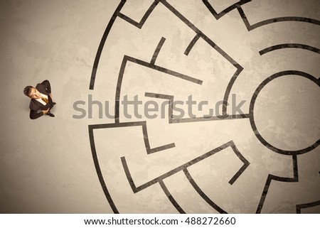 Lost business man looking for a way in circular labyrinth concept