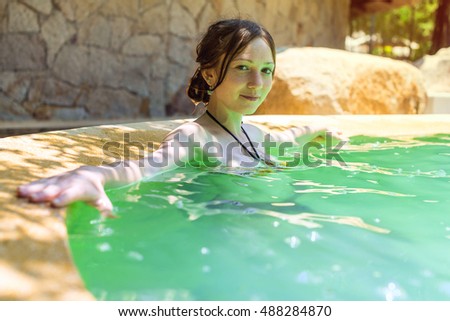 Beautiful woman resting in pool, hot springs, Spa