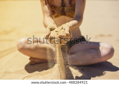 Sand as the time slips through your fingers. Girl holding a sand sea background