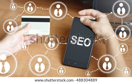 Hand keep smart phone with seo symbol. Holding smartphone with SEO word. Search engine optimization, website, mobile, smartphone, network, online, 	
promotion, advance, advancement, progression.