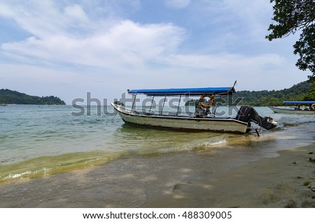 Tourist boat anchored over cloudy and blue sky background