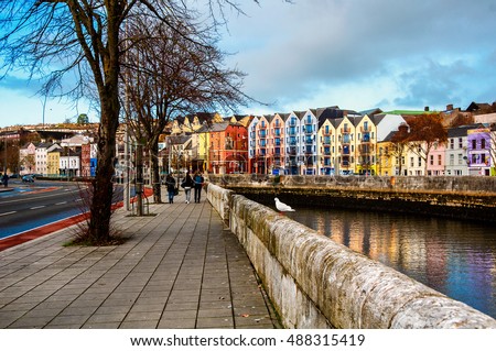 Bank of the river Lee in Cork, Ireland city center with various shops, bars and restaurants. People walking at the street of third largest city in country Royalty-Free Stock Photo #488315419