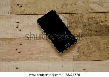 Useless, Broken smart phone with space in wooden texture background

