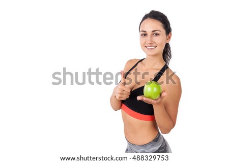 Close up of a girl with a green apple smiling. She is showing thumb up. Concept of vegetarian style of life and eating your veggies. Mock up